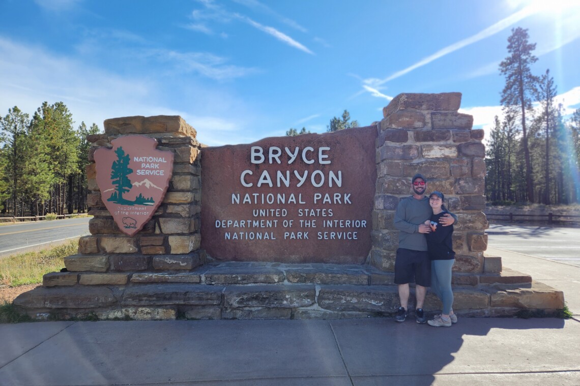 Stefani and Kelly outside of the Bryce Canyon National Park Sign.